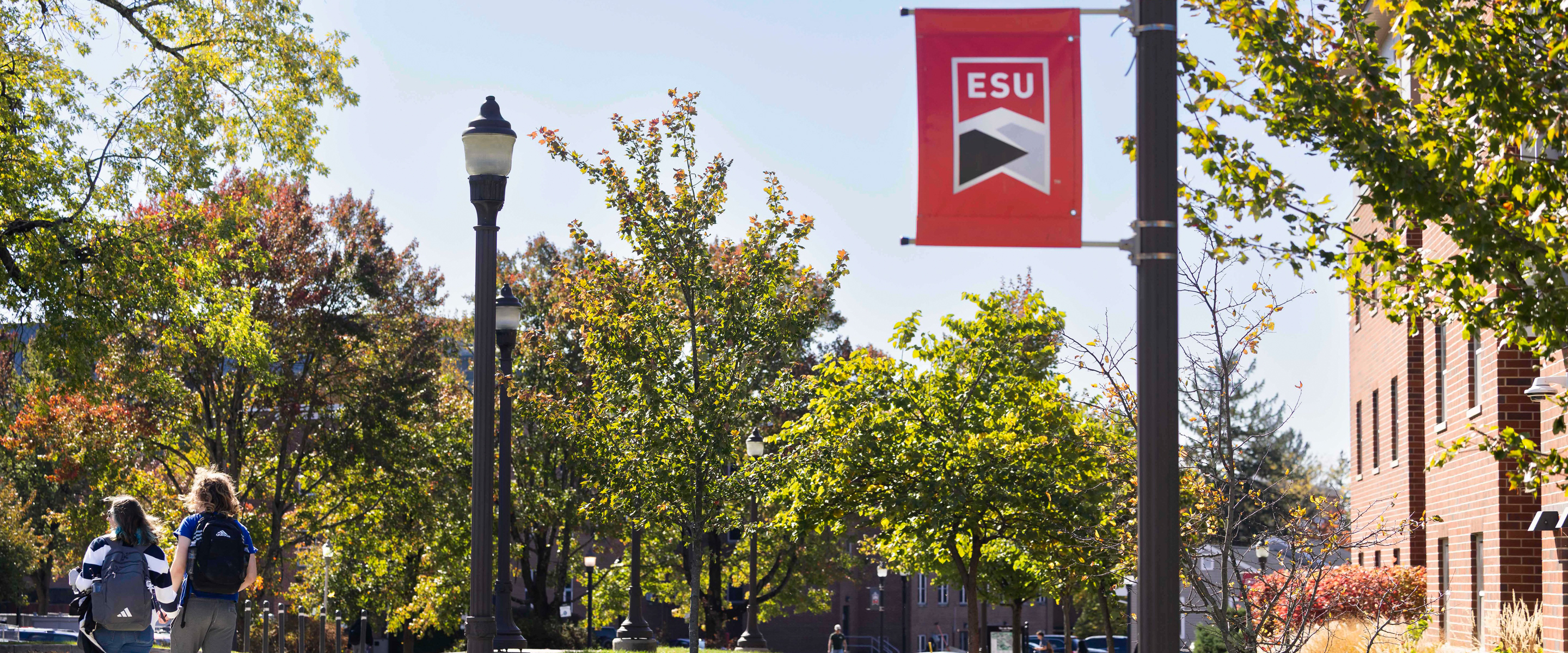 ESU Flag pole with students walking around