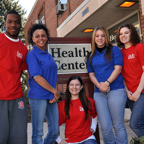 students standing in front of health services sign